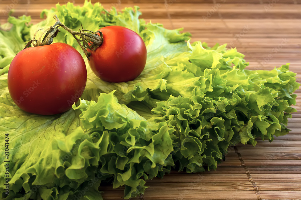 Fresh salad and tomatoes on wooden surface Fresh salad and tomatoes on wooden surface
