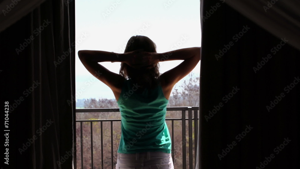 Woman unveil curtains, stretching and walking out on terrace Woman unveil curtains, stretching and walking out on terrace