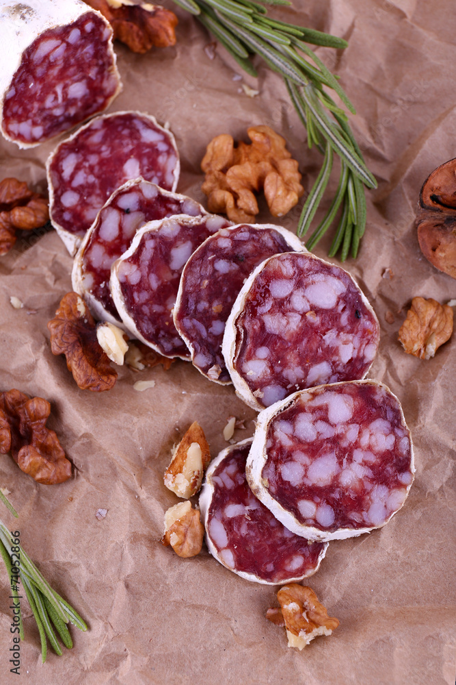 French salami and walnuts on craft paper background French salami and walnuts on craft paper background