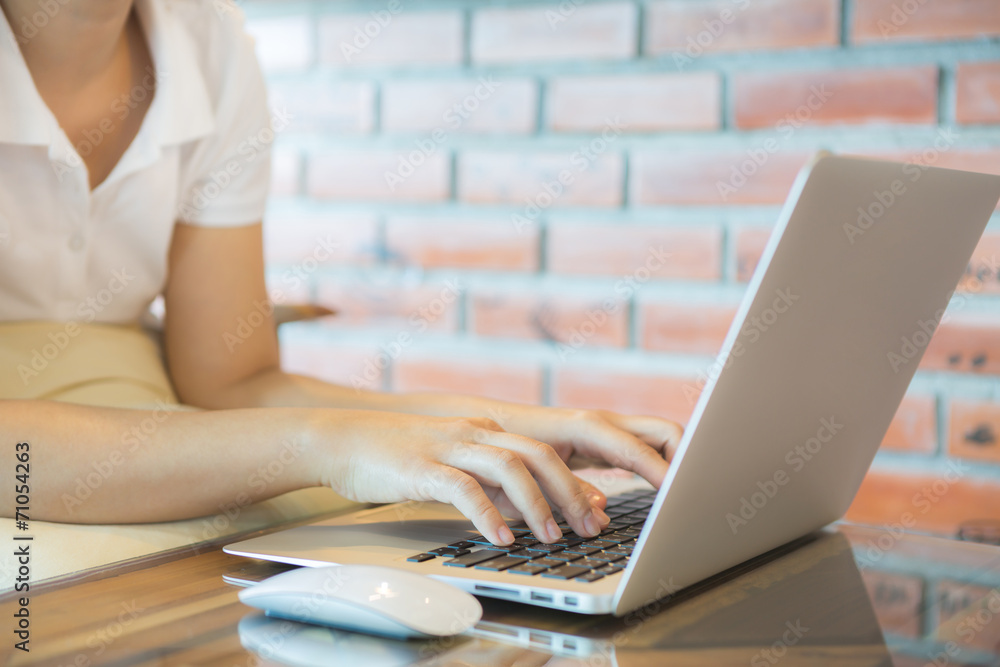 Fototapeta premium Closeup of business woman hand typing on laptop keyboard with mo