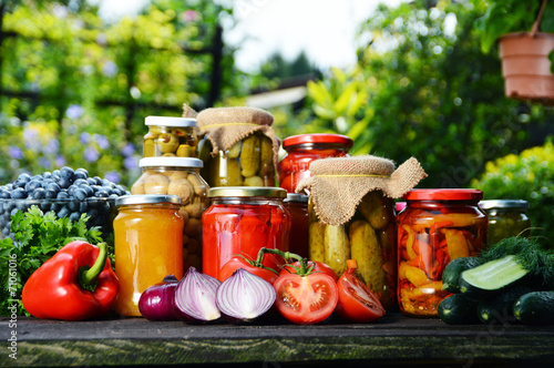Canvas Print Jars of pickled vegetables in the garden. Marinated food