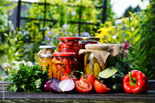 Jars of pickled vegetables in the garden. Marinated food
