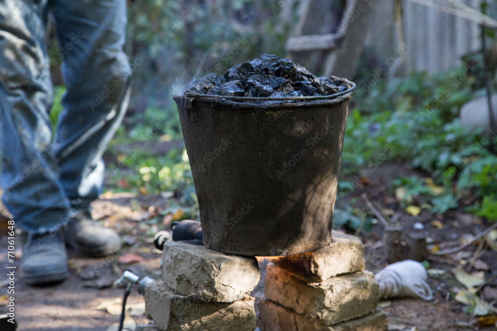 a bucket of tar on the fire, for roof repairs a bucket of tar on the fire, for roof repairs