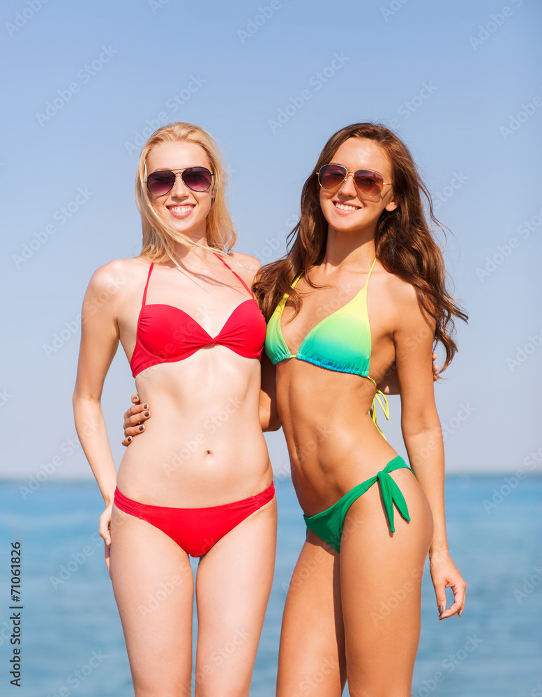 two smiling young women on beach