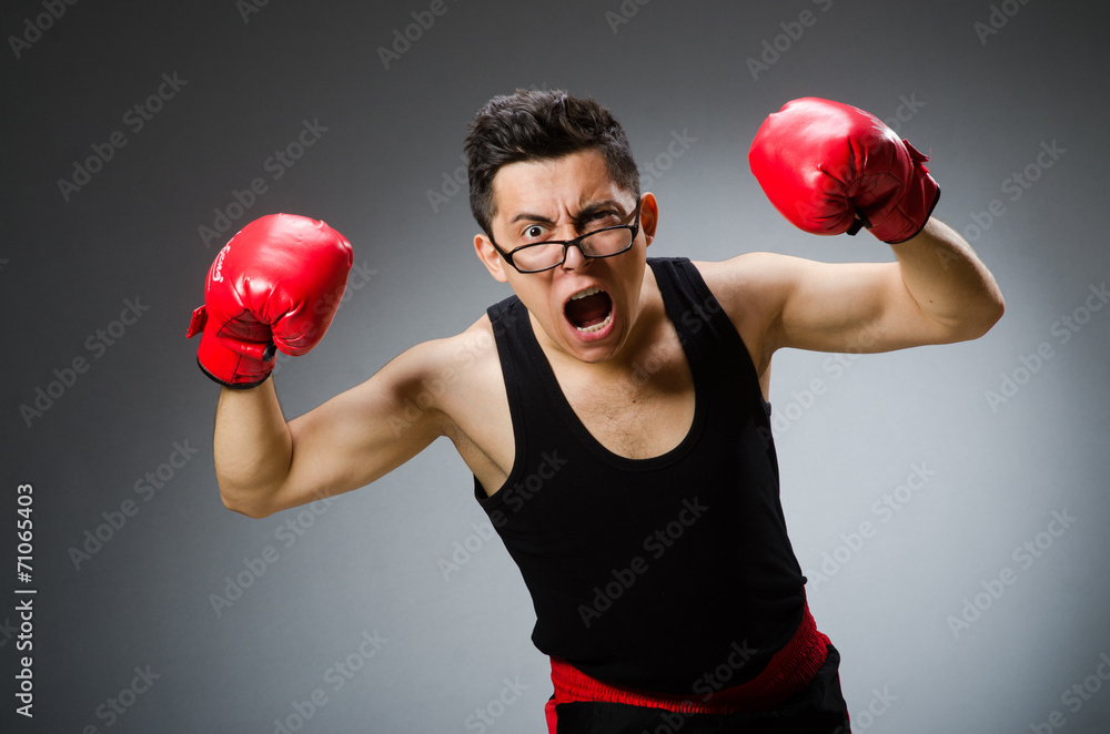 Funny boxer with red gloves against dark background Funny boxer with red gloves against dark background