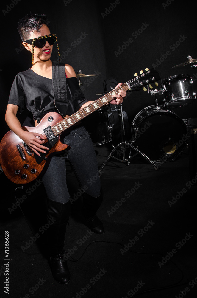 Fototapeta premium Young woman playing guitar during the concert