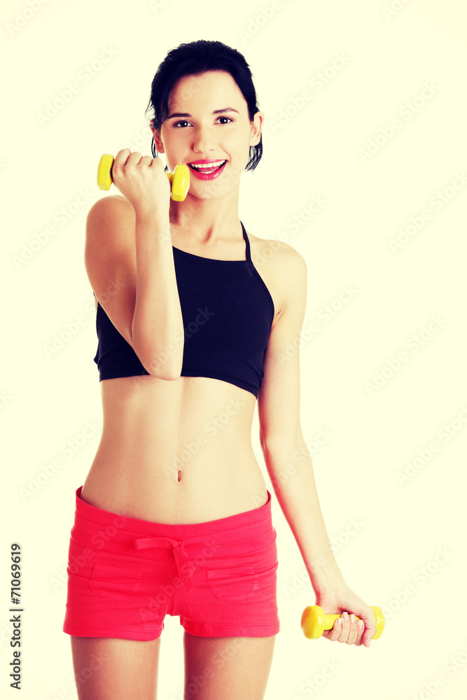 Fitness girl is working out with dumbbells Fitness girl is working out with dumbbells