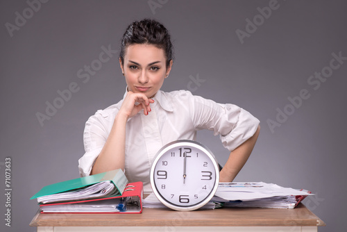 Foto Waist-up portrait of young girl sitting at the table in office