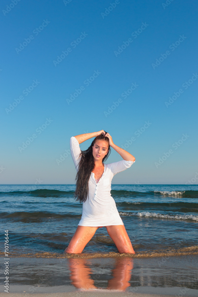 woman wearing  white t-shirt posing on the beach