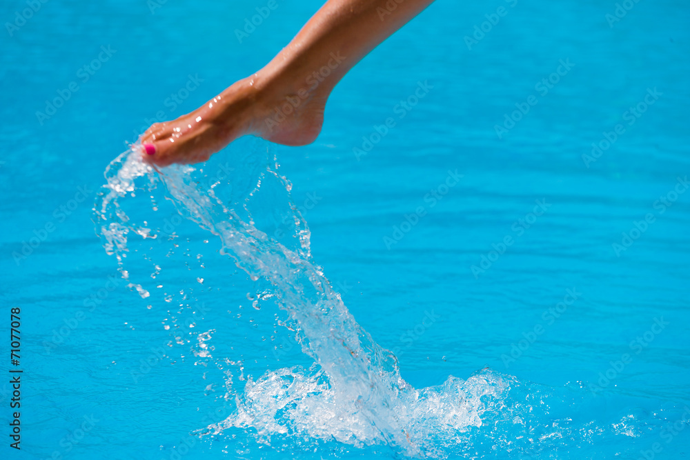 girl's beauty legs in the pool making splashes