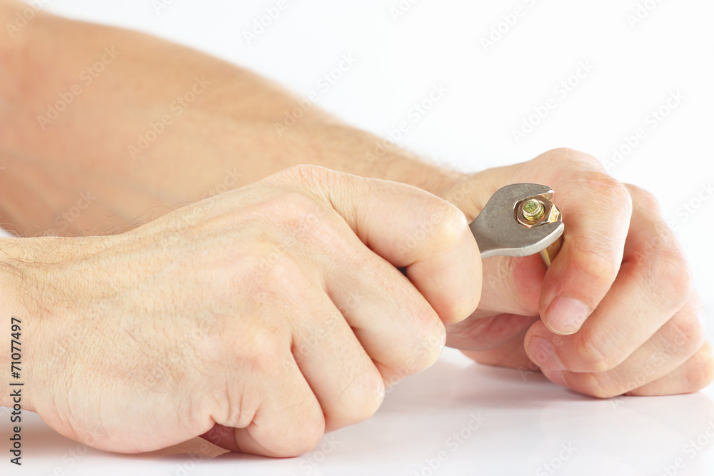 Hand of serviceman with a wrench to tighten the nut