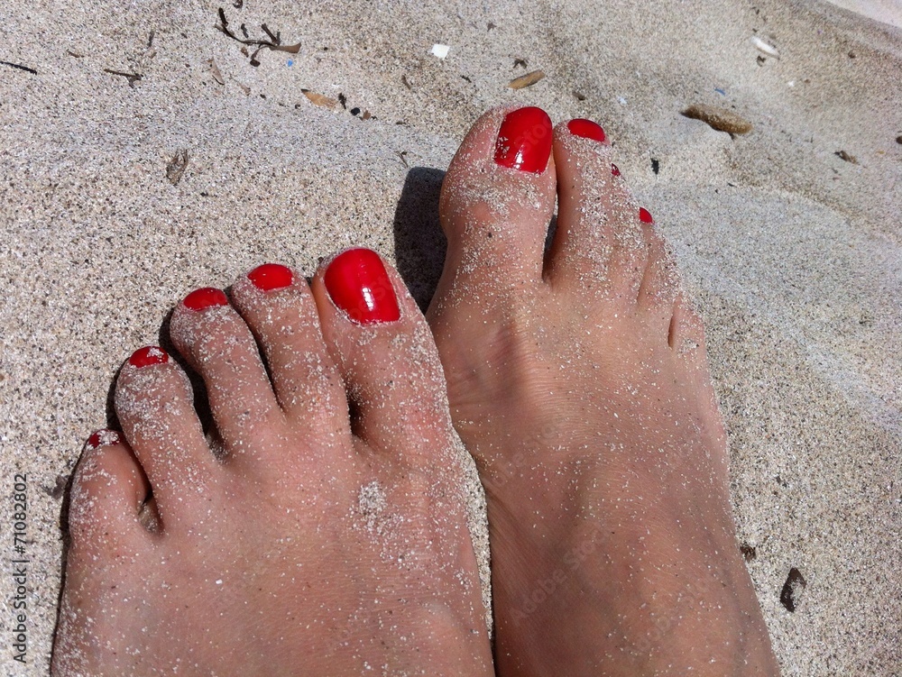 rote Fussnägel im Sand Stock-Foto | Adobe Stock
