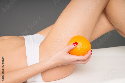 Frau mit einer Orange in der Hand