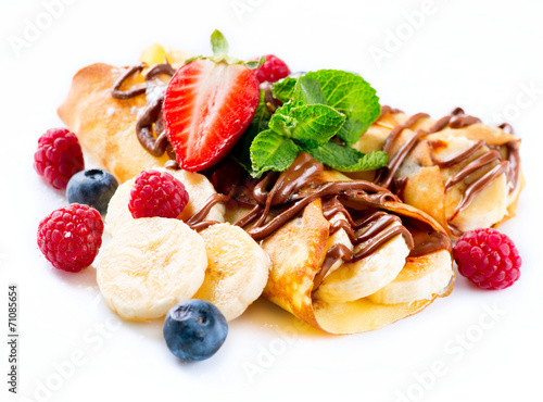 Crepes with banana, chocolate and berries over white