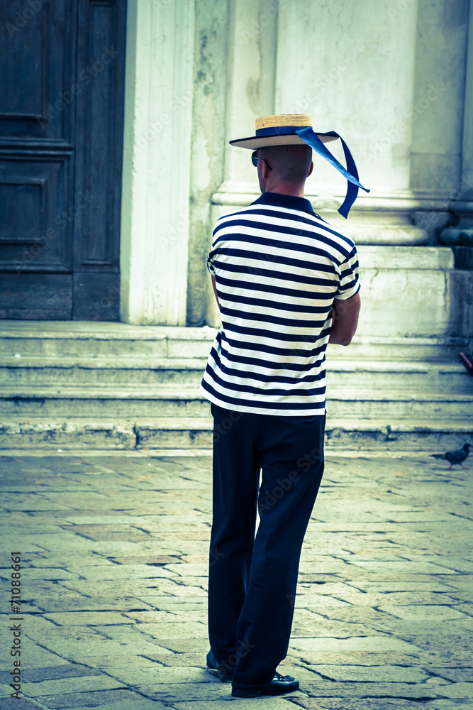 Gondolier on the docks awaiting tourists in Venice, Italy