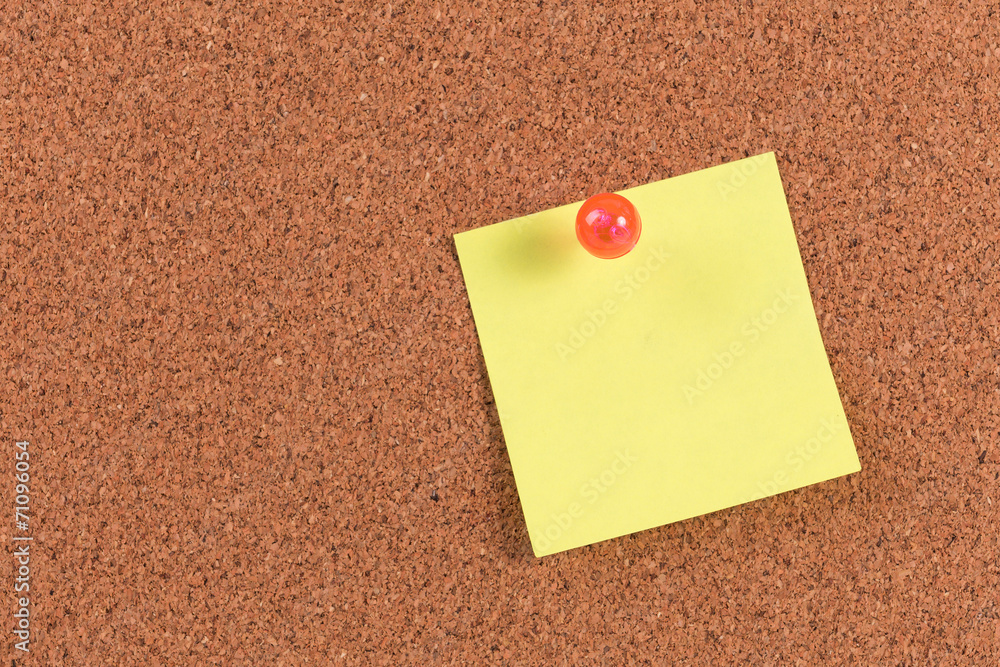yellow reminder sticky note on cork board, empty space for text yellow reminder sticky note on cork board, empty space for text