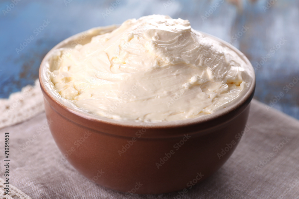 Fresh homemade butter in bowl, on color wooden background Fresh homemade butter in bowl, on color wooden background