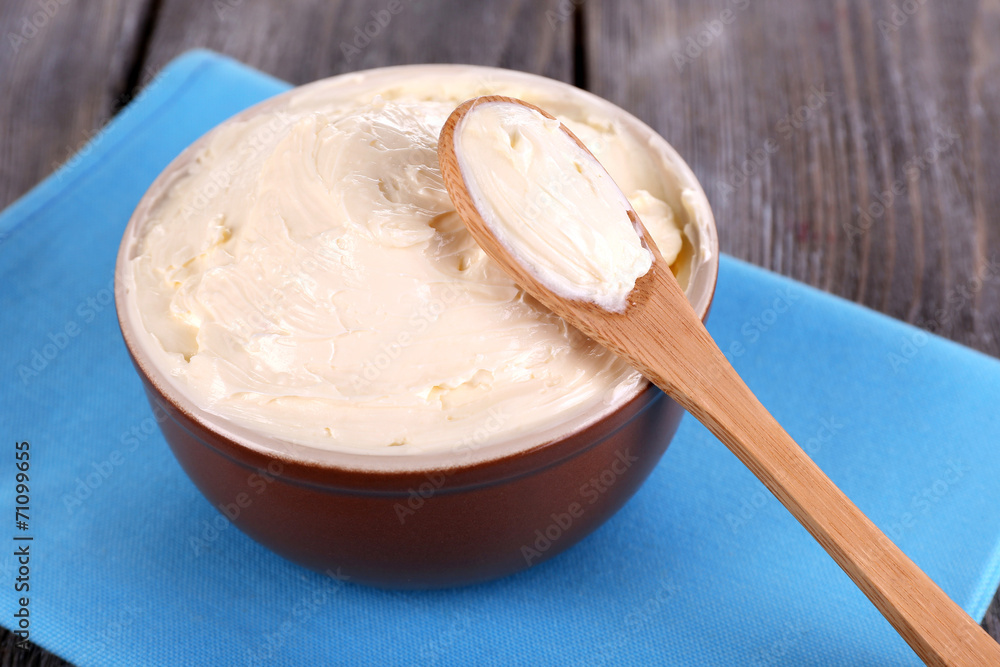 Fresh homemade butter in bowl, on color wooden background Fresh homemade butter in bowl, on color wooden background