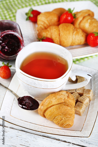 Breakfast with tea, jam and fresh croissants