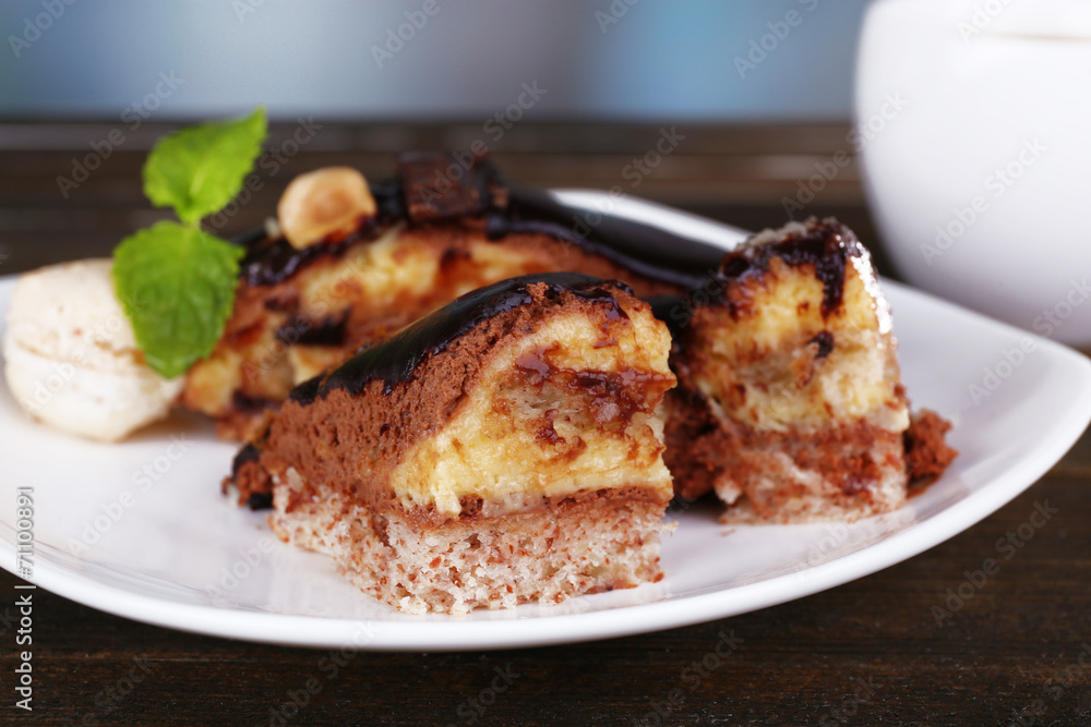 Pieces of chocolate cake on plate and cup of tea on wooden