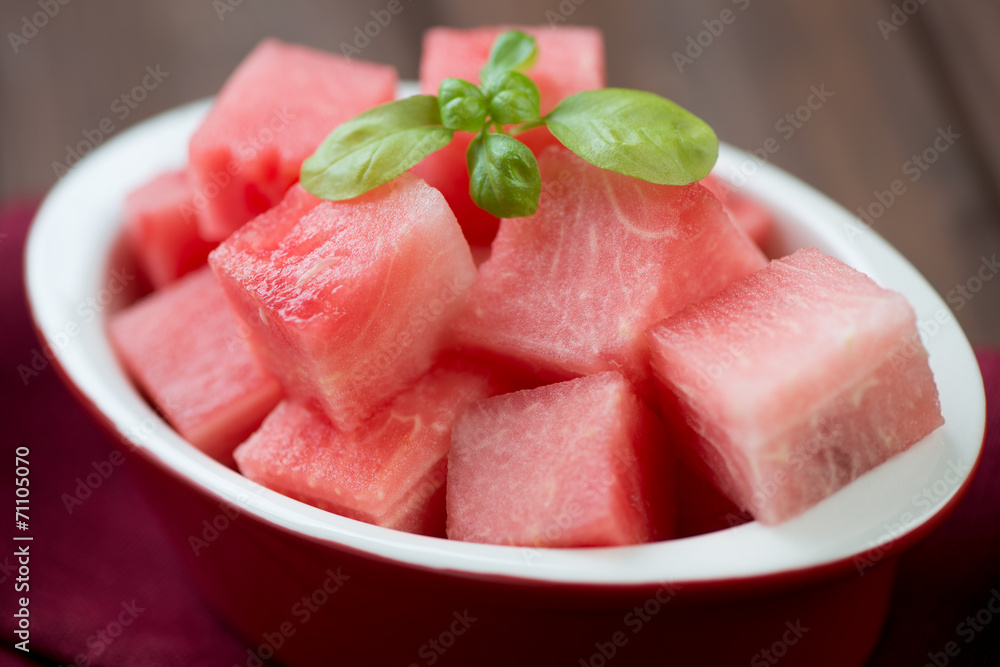 Close-up of watermelon cubes with basil leaves, horizontal shot