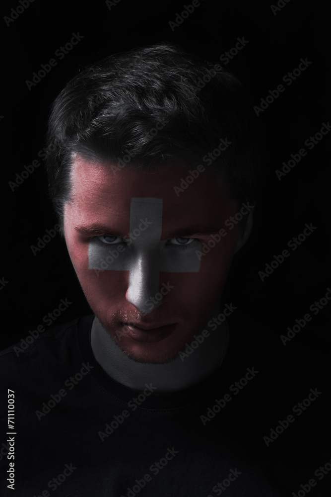 serios man face with painted flag colors of Switzerland serios man face with painted flag colors of Switzerland