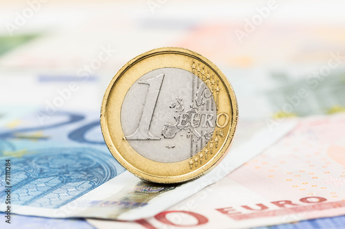 Euro money banknote and coin close-up (focus on coin)