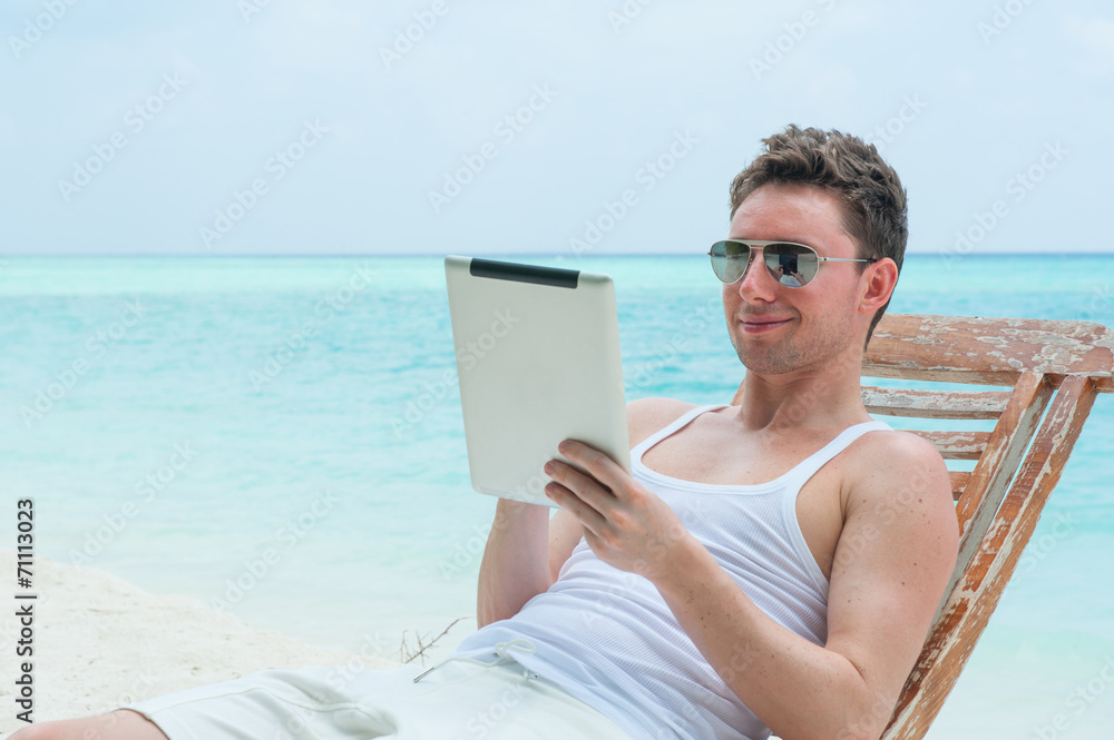 Man with tablet on beach, sea view