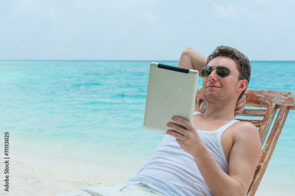 Man with tablet on beach