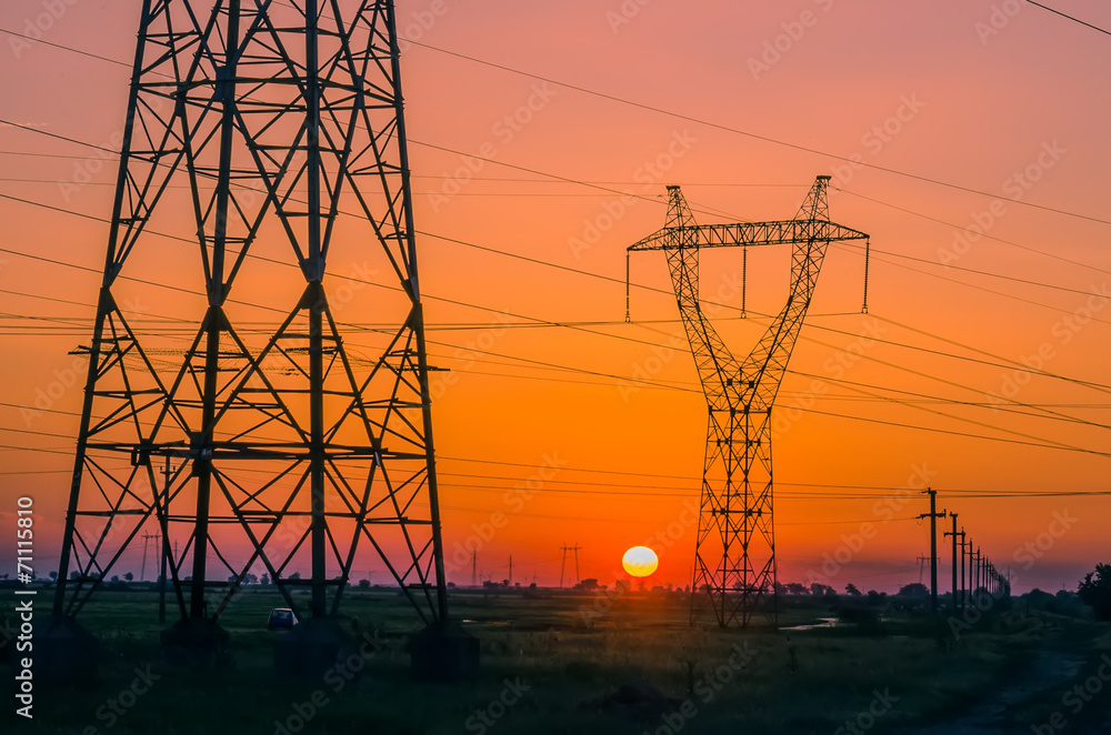 Silhouette electricity pylons during sunset
