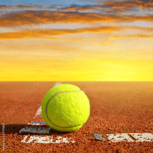 Tennis ball on a tennis clay court in the sunset © vencav