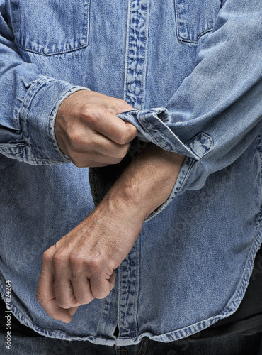 Fotografija Man in denim shirt rolling up his sleeves