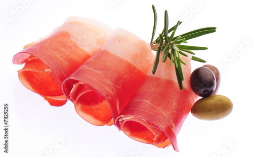 Sliced prosciutto with rosemary and olives on white background