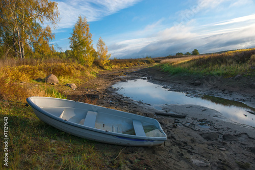 Boat on the dry river autumn morning