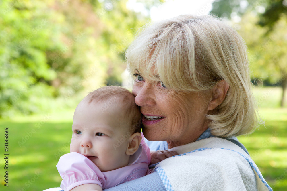Grandmother holding granddaughter outdoors Grandmother holding granddaughter outdoors