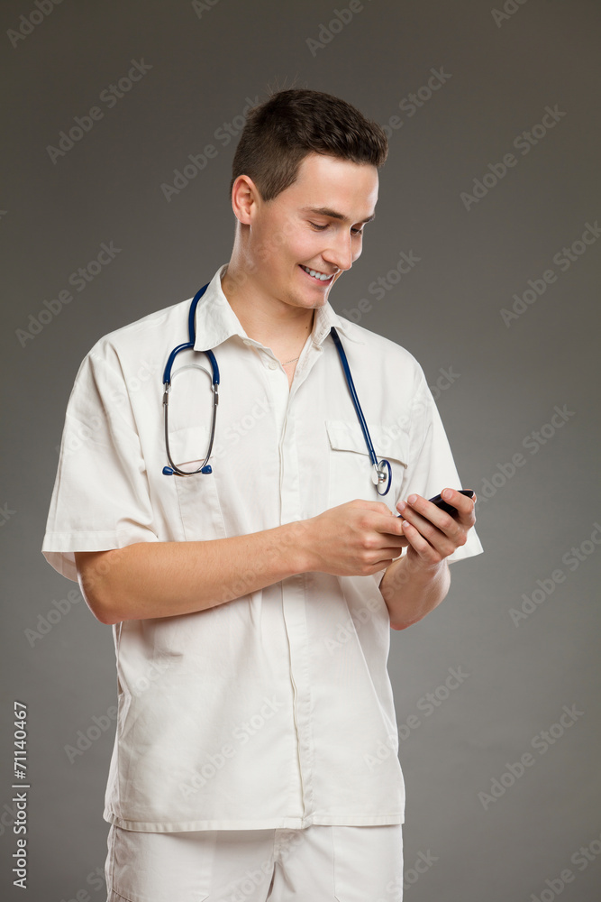 Smiling doctor using mobile phone