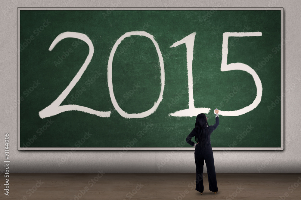 Woman writes number 2015 on blackboard Woman writes number 2015 on blackboard