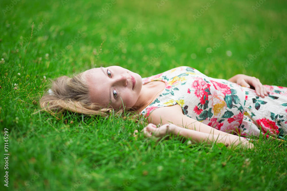 Young girl lying on the grass on a summer day Young girl lying on the grass on a summer day
