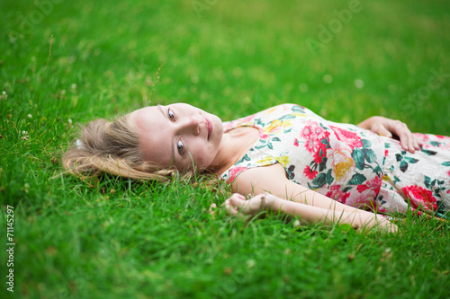 Young girl lying on the grass on a summer day