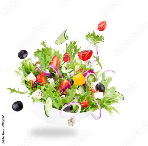 Foto Fresh salad with flying vegetables ingredients