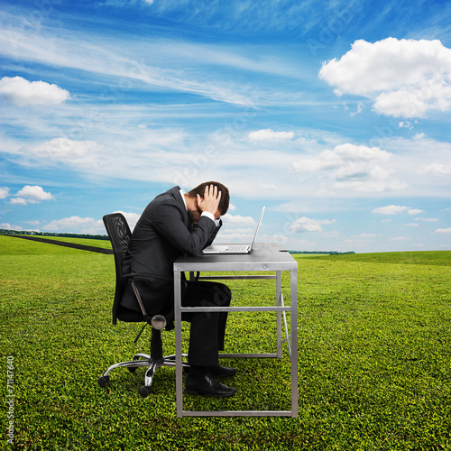 Photography sad man sitting at the table with laptop