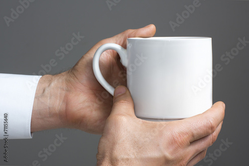 White cup in the hands.