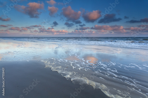 sunrise sky reflected in North sea waves