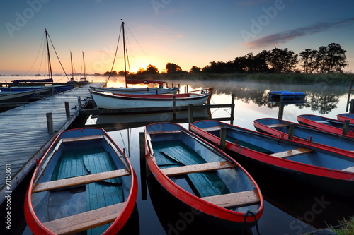 boats and yachts on lake at sunrise