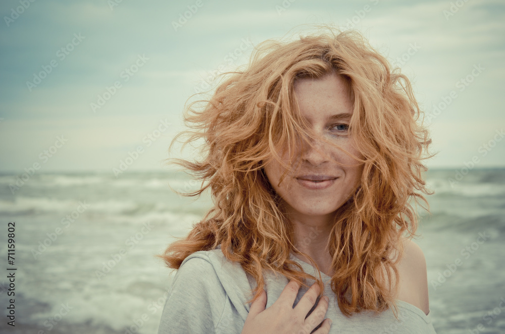Portrait of fancy and beautiful red-haired girl on the seaside.