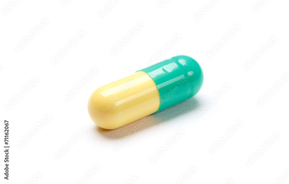 Green capsule, isolated on white. Health care concept.