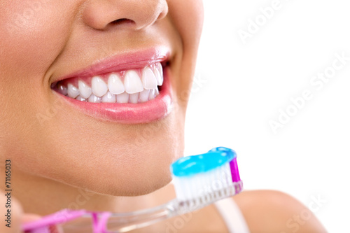 woman with healthy teeth holding a tooth-brush