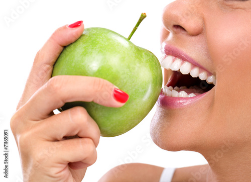 closeup of the face of a woman eating a green apple
