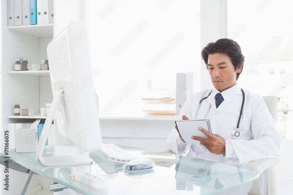 Serious doctor writing down some notes Serious doctor writing down some notes