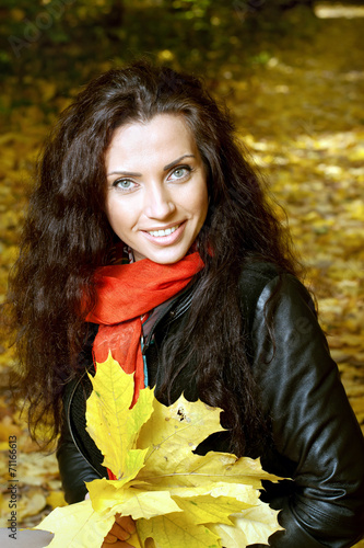 Beautiful girl sitting on yellow leaves